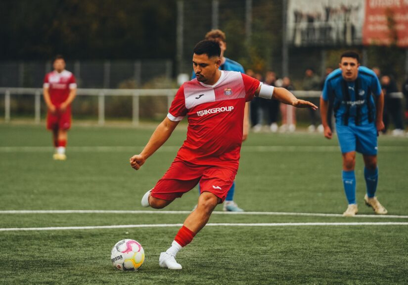 Football player in action on the pitch, showcasing athletic skill.