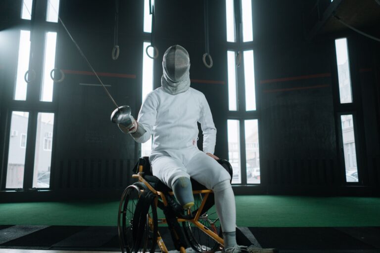 A fencer in protective gear practicing indoors, showcasing adaptive sports.