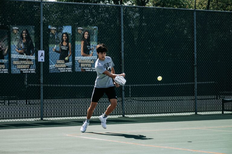 A teenager in action on an outdoor tennis court in Milwaukee, Wisconsin.
