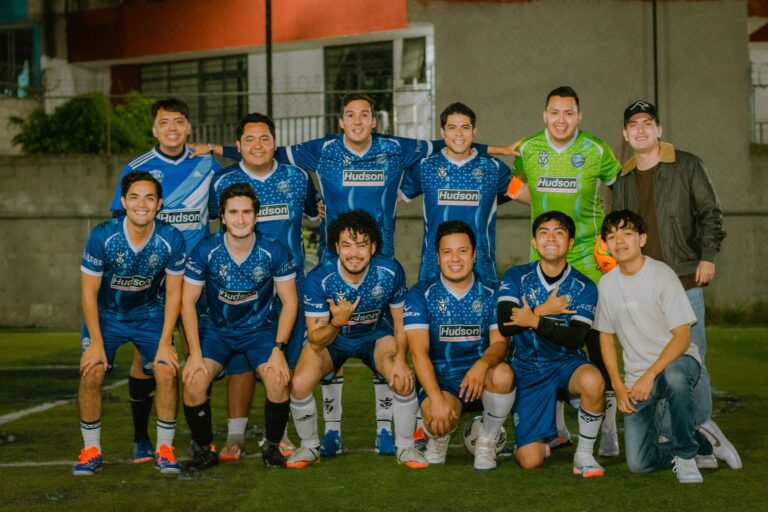 A group of young men posing for a soccer team photo on an outdoor field.