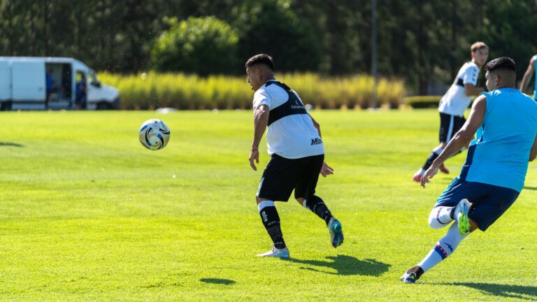 Players in action during a soccer training session outdoors on a sunny day.