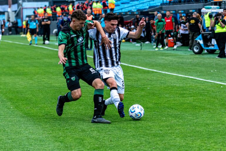 Dynamic action shot of two soccer players vying for control of the ball on the field.