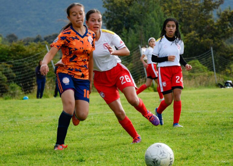 Action-packed women's soccer match showing players competitively engaging on the field.
