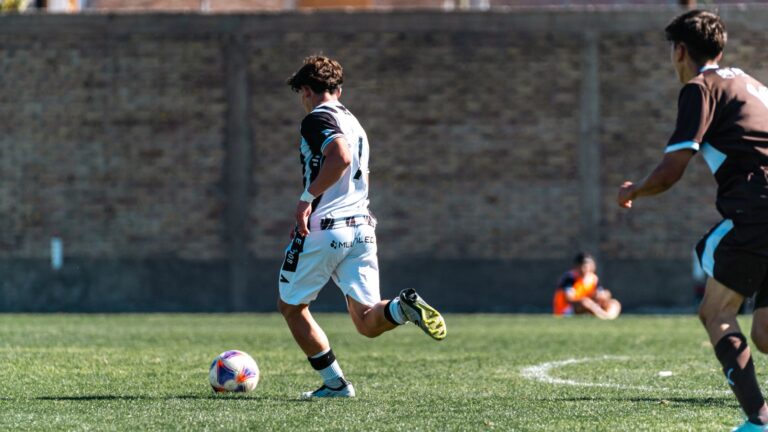 Players engaged in intense soccer action on a sunny outdoor field. Energetic and dynamic sports moment.