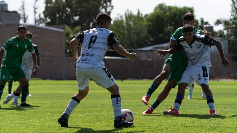 Dynamic action scene of a soccer match on a sunny day with players contesting the ball.