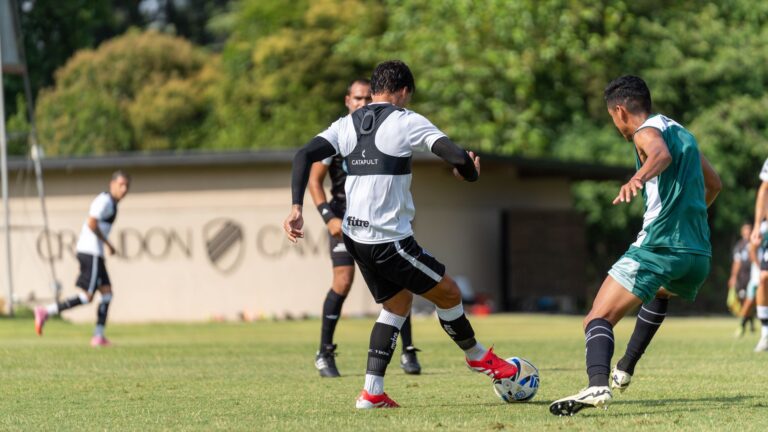Dynamic outdoor soccer match with players intensely focused on the ball.