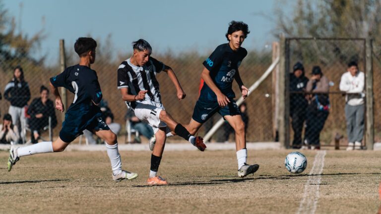 Intense moment from a youth soccer match with players in motion on a grassy field.