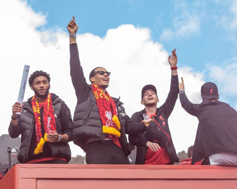 Fans celebrate with Liverpool FC players during a victory parade in Liverpool, England.