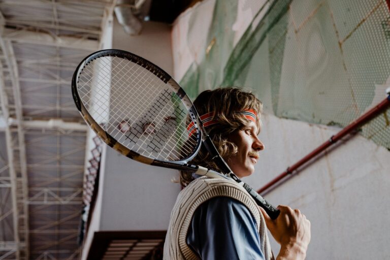 Focused tennis player holding racket indoors, ready for the match.