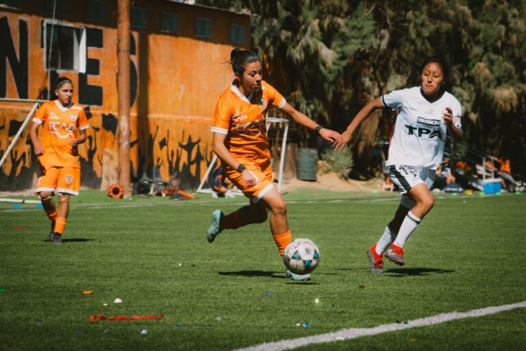 Exciting women's football match with players in action on a sunny day in Chile.