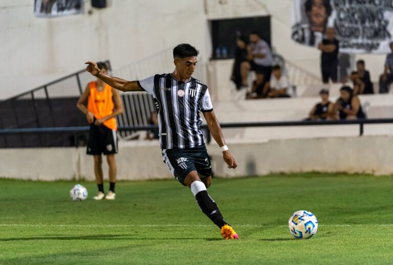 An intense moment as a soccer player executes a powerful kick on the field during a competitive match.