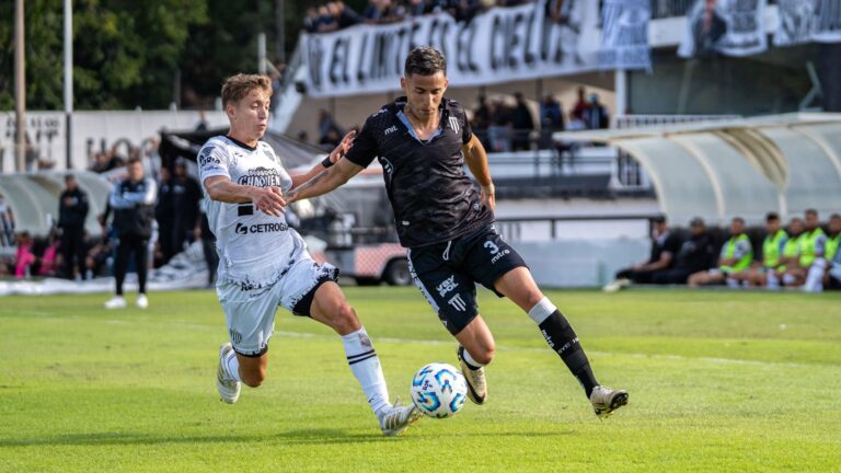 Two soccer players in action during a competitive outdoor match.