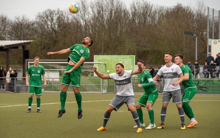 Dynamic action shot of adult men playing soccer outdoors, illustrating teamwork and athleticism.