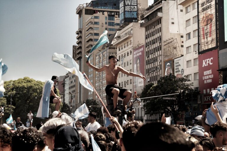 Vibrant celebration in Buenos Aires featuring a festive crowd with flags in the city streets.