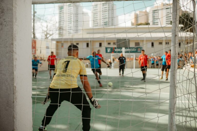 Goalkeeper prepares to defend during an indoor soccer game. Action-packed sports moment.