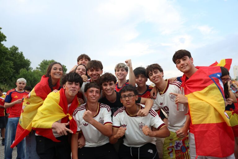 A group of enthusiastic Spanish football fans celebrating outdoors in Madrid.