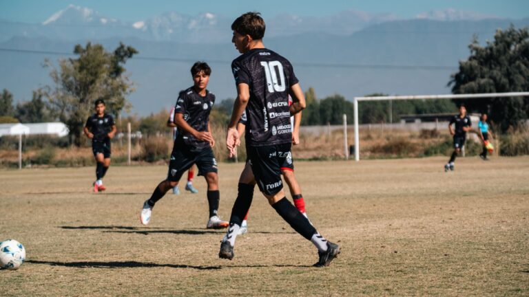 Teen soccer game in a sunny field with stunning mountain views in the background.