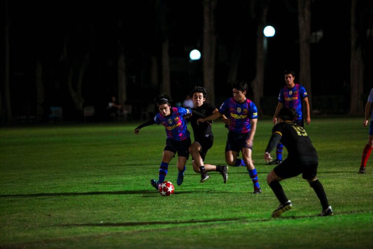 Action-packed night soccer match with players competing under field lights.