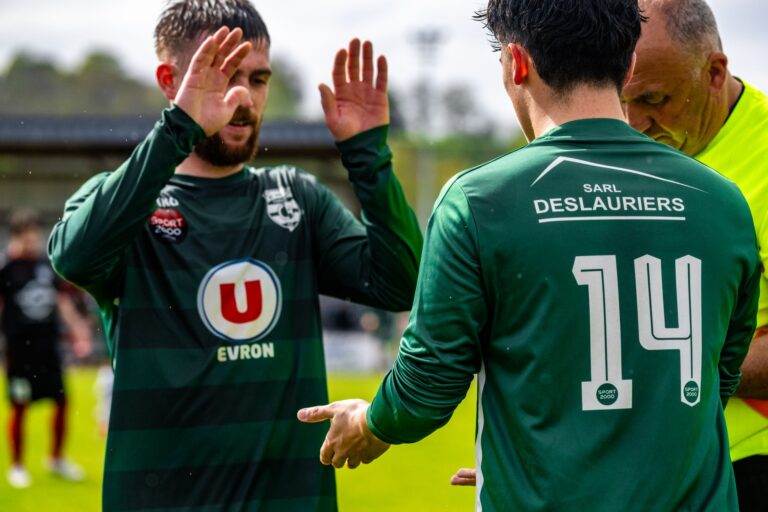 Football players exchanging gestures during a match in France, showcasing sportsmanship.