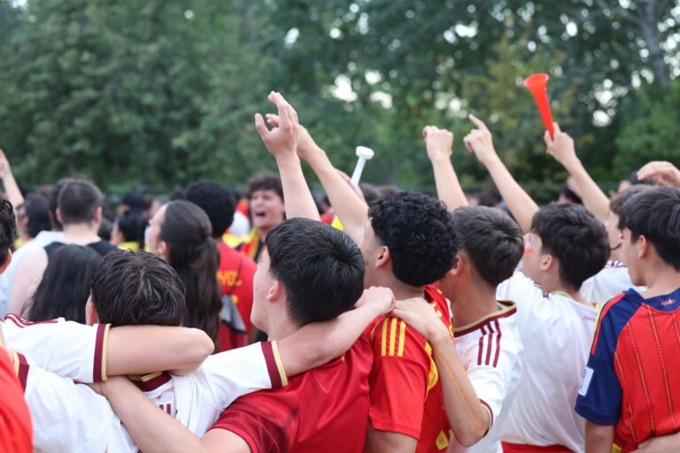 Excited fans celebrate at an outdoor sports event in Madrid, expressing joy and unity.