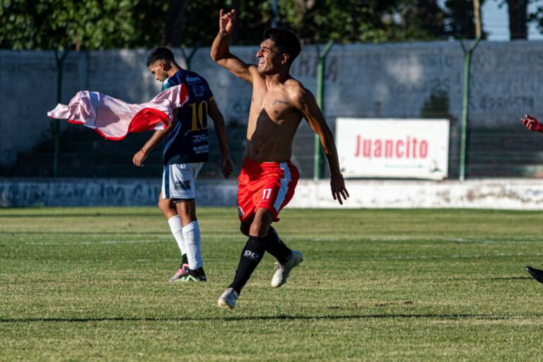 Player celebrating a goal on the field with passionate gesture during a football match.