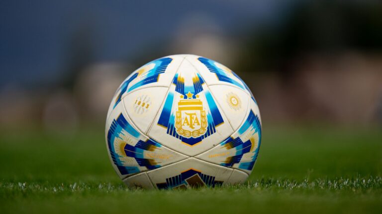 Detailed view of a soccer ball with AFA logo on a green field.