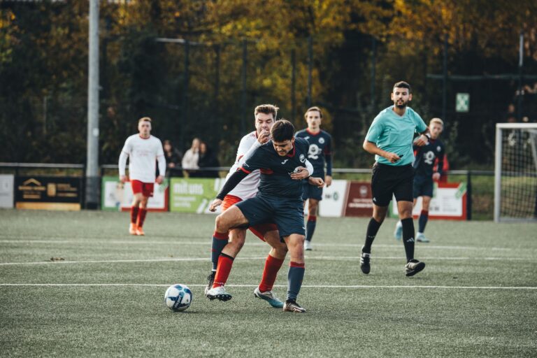Players in action during an outdoor soccer match on a grass field.