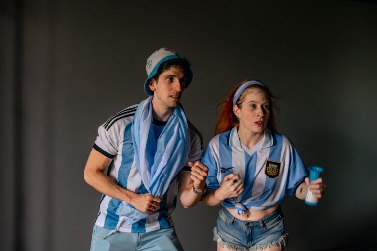 Two enthusiastic Argentina soccer fans cheer during a match. Perfect for sports and celebration themes.