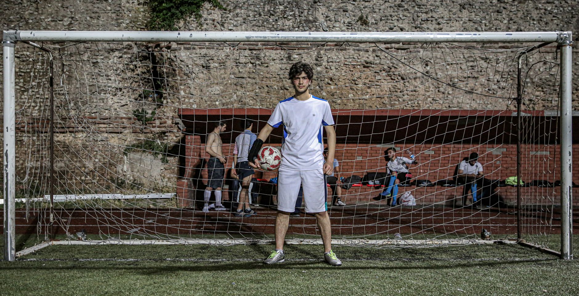 A young soccer player standing in front of a goal with a ball in Istanbul, Turkey.