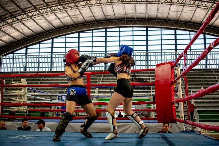 Dynamic kickboxing match between two women in a stadium ring.