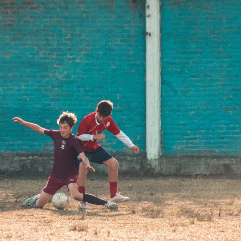Two teenage soccer players engage in a competitive match outdoors in Buenos Aires, Argentina.
