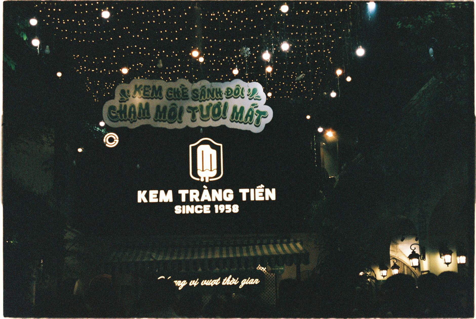 Beautiful night scene in Hanoi showcasing Kem Tràng Tiền ice cream shop decorated with lights.