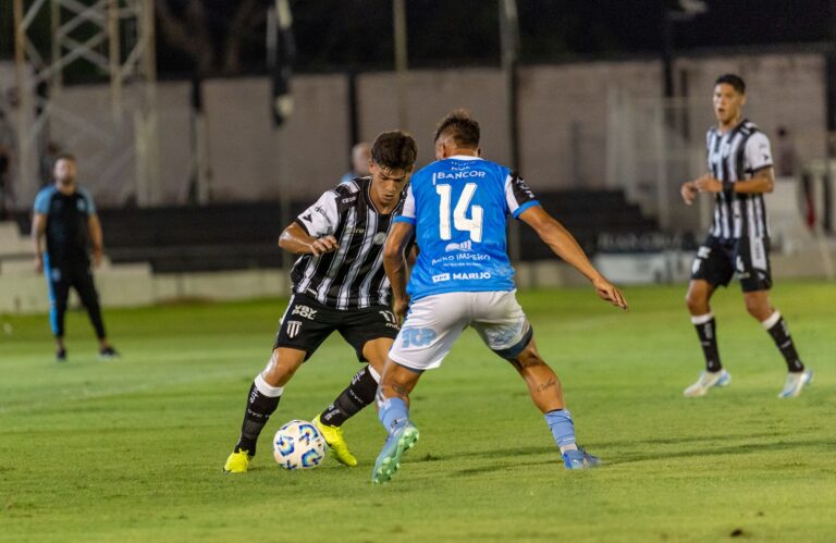 Players in a competitive soccer match showcasing skills on a well-maintained grass field under bright stadium lights.
