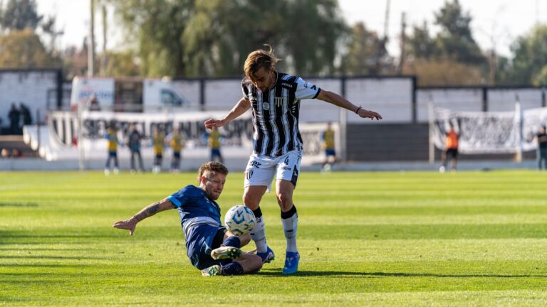 Two soccer players battle for the ball during a competitive outdoor match.