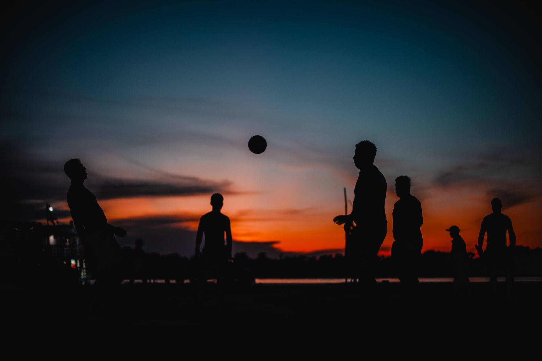Silhouetted group playing soccer on the Amazon Riverbank at sunset in Manaus, Brazil.