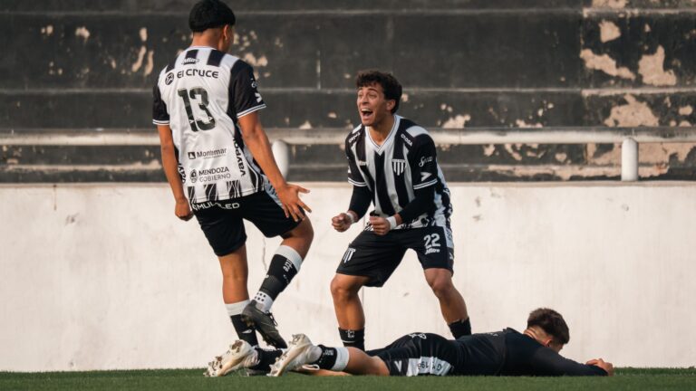 Football players in black and white jerseys celebrate a goal on the field.