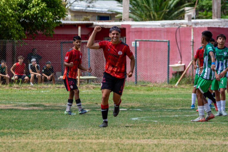 Teen soccer player celebrates on the field during an outdoor match game.