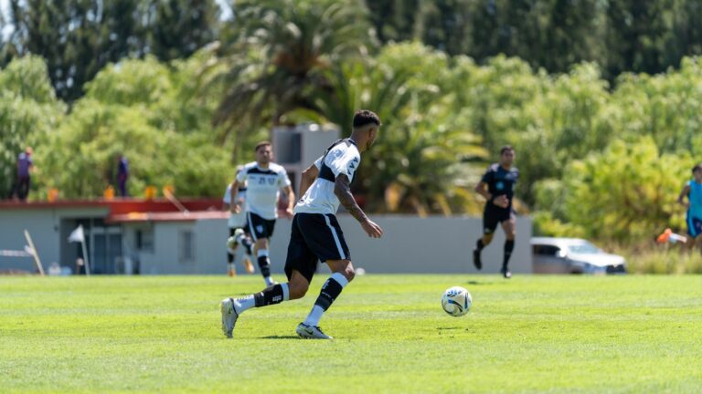Action shot of football players during a match on a sunny day.
