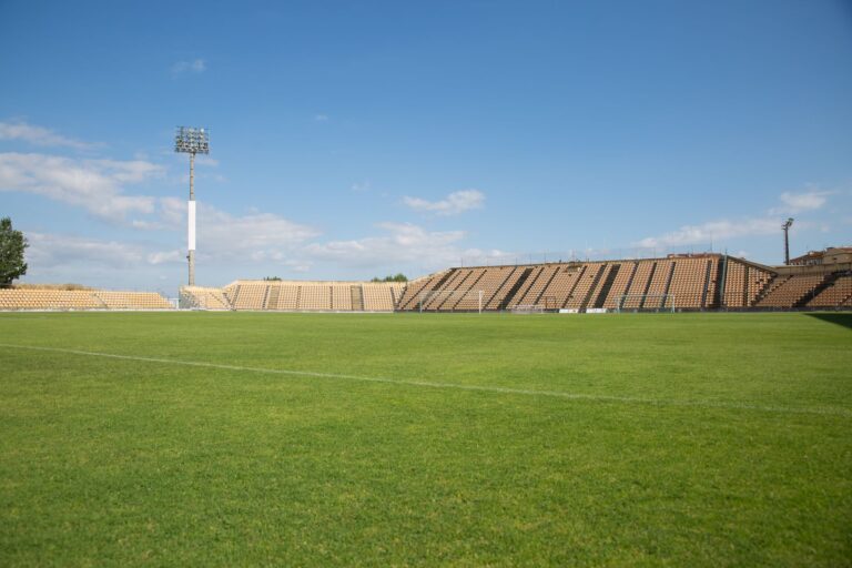 A bright, clear day at an empty football stadium in Portugal, perfect for sports events.