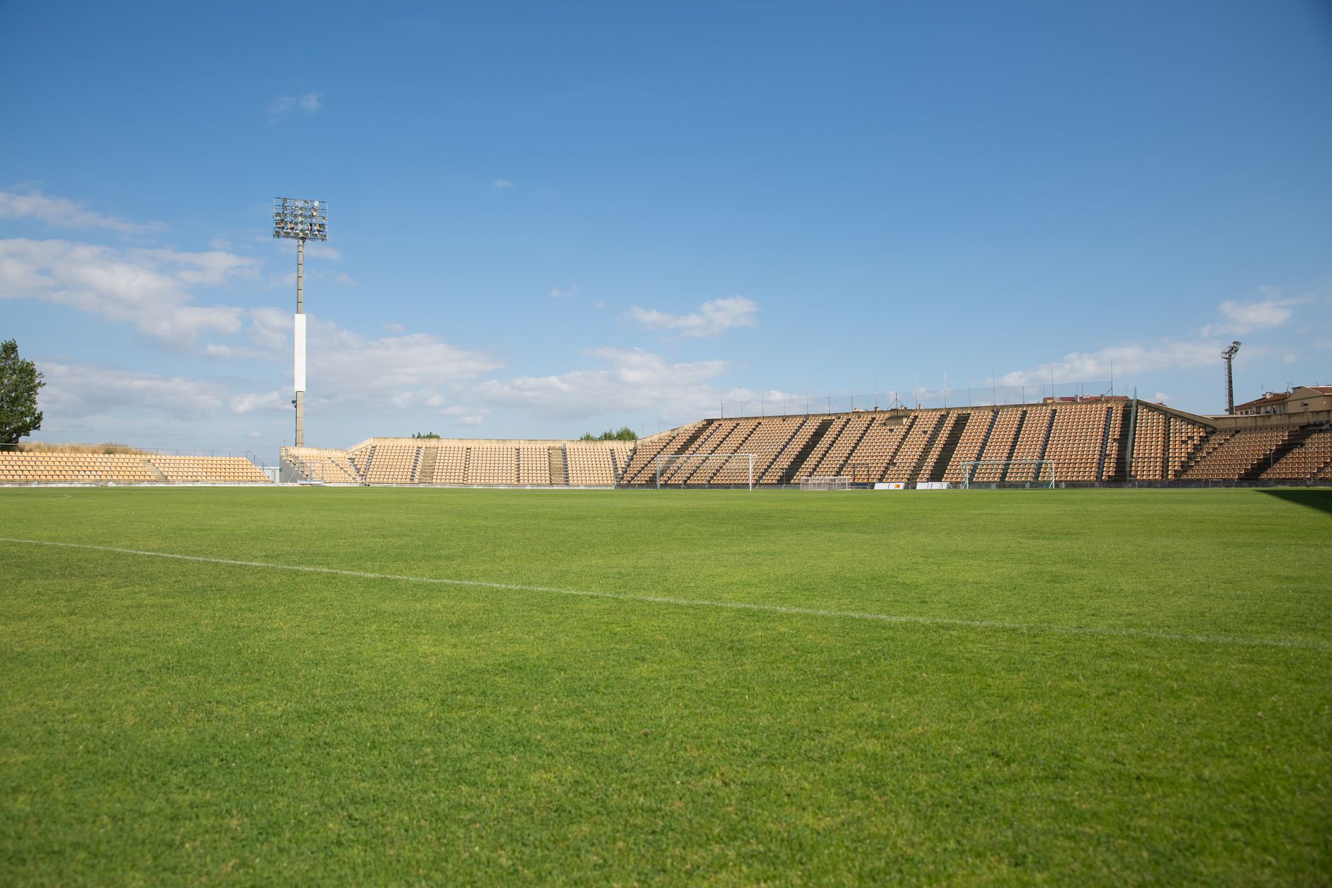 A bright, clear day at an empty football stadium in Portugal, perfect for sports events.
