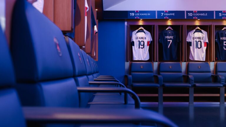 Professional football locker room in Paris with player jerseys displayed.