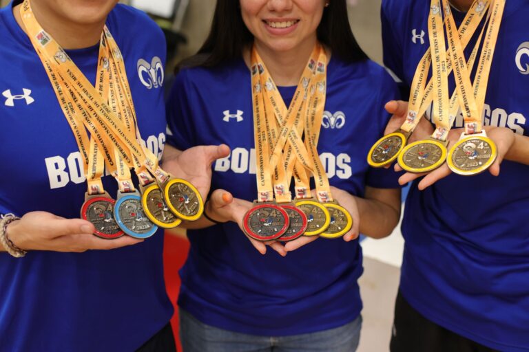 Group of athletes displaying their gold, silver, and bronze medals with pride and joy.