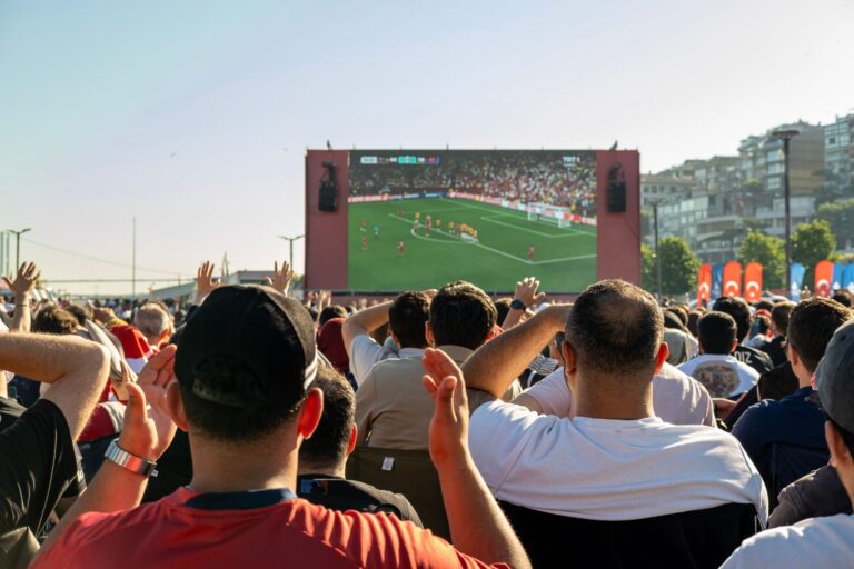 Crowd watching a soccer game on a large screen outdoors in Istanbul, Türkiye.
