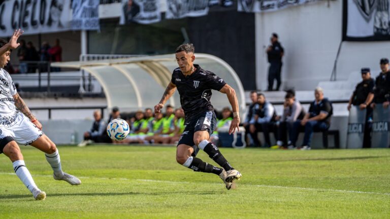 Soccer players in action during a competitive match on a sunny day.