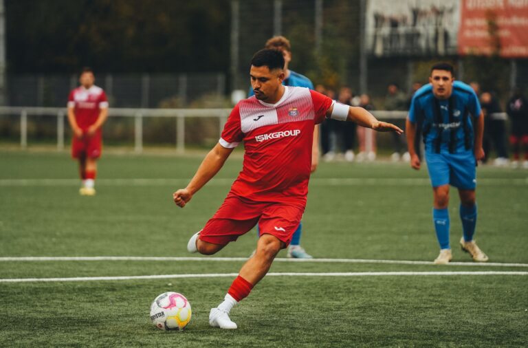 Football player in action on the pitch, showcasing athletic skill.