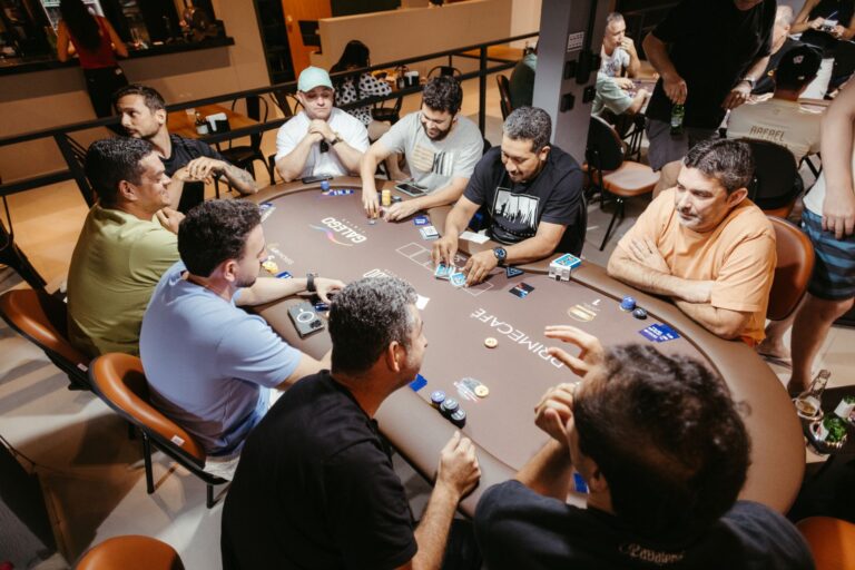 Group of men engaged in a poker game at an indoor setting, showcasing social interaction.