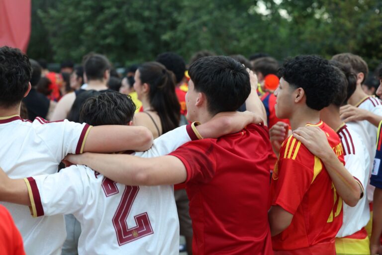 Crowd of fans in Spain jerseys celebrating at an outdoor event in Madrid