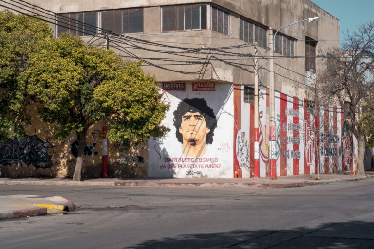 Vibrant street art mural on a building corner in Córdoba, Argentina, featuring a portrait.