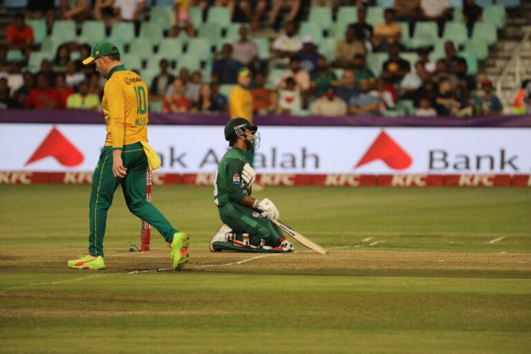 Dynamic cricket scene with players in action on the field during a match.