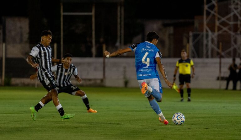 Soccer players in action during a night match, showcasing athletic skill.